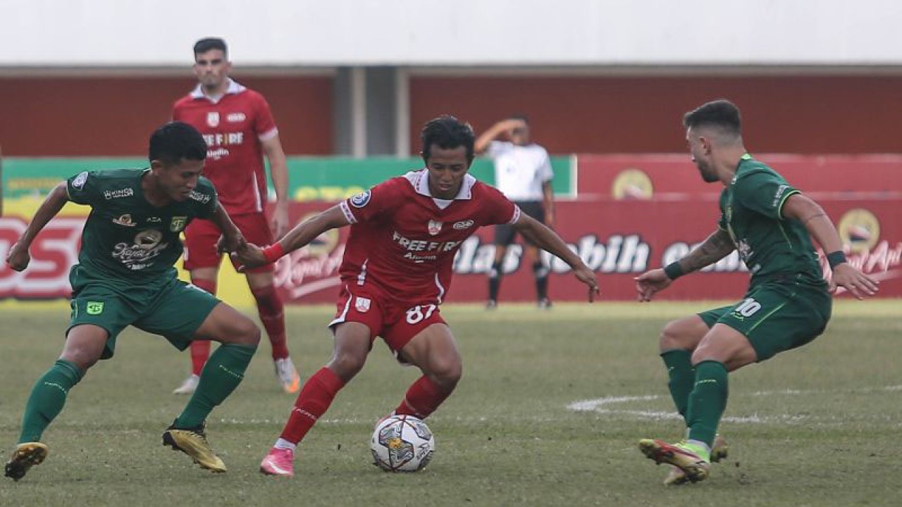 Arsip - Pesepakbola Persis Solo Shulton Fajar (tengah) mencoba melewati pesepakbola Persebaya Surabaya Higor Vidal (kanan) pada pertandingan BRI Liga 1 di Stadion Maguwoharjo, Sleman, DI Yogyakarta, Rabu (21/12/2022). Pertandingan tersebut berakhir imbang dengan skor 0-0. ANTARA FOTO/Hendra Nurdiyansyah/YU