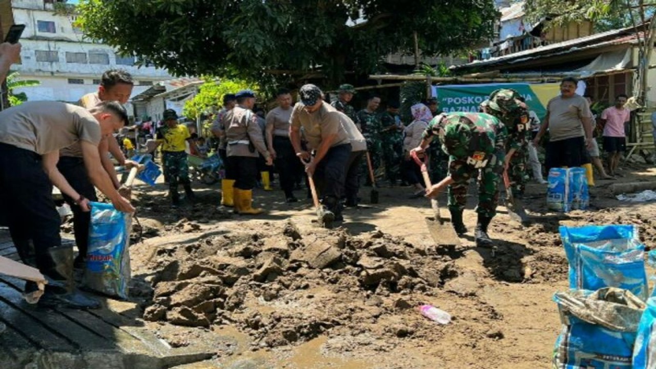 Personel Polri bersama TNI kerja bakti di lokasi banjir dan tanah longsor di Kota Manado. ANTARA/HO-Humas Polda Sulut