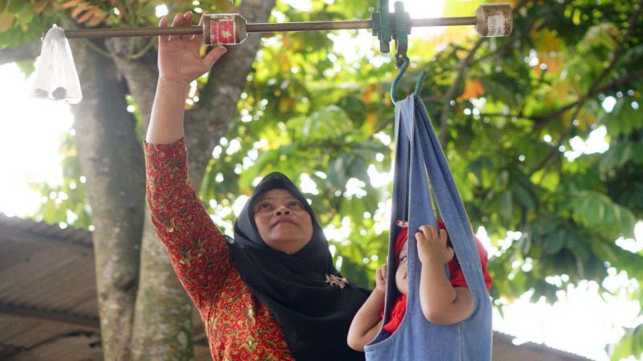 Petugas menimbang berat badan balita saat pelayanan posyandu untuk penanganan stunting (gangguan pertumbuhan). ANTARA FOTO/Destyan Sujarwoko/rwa.