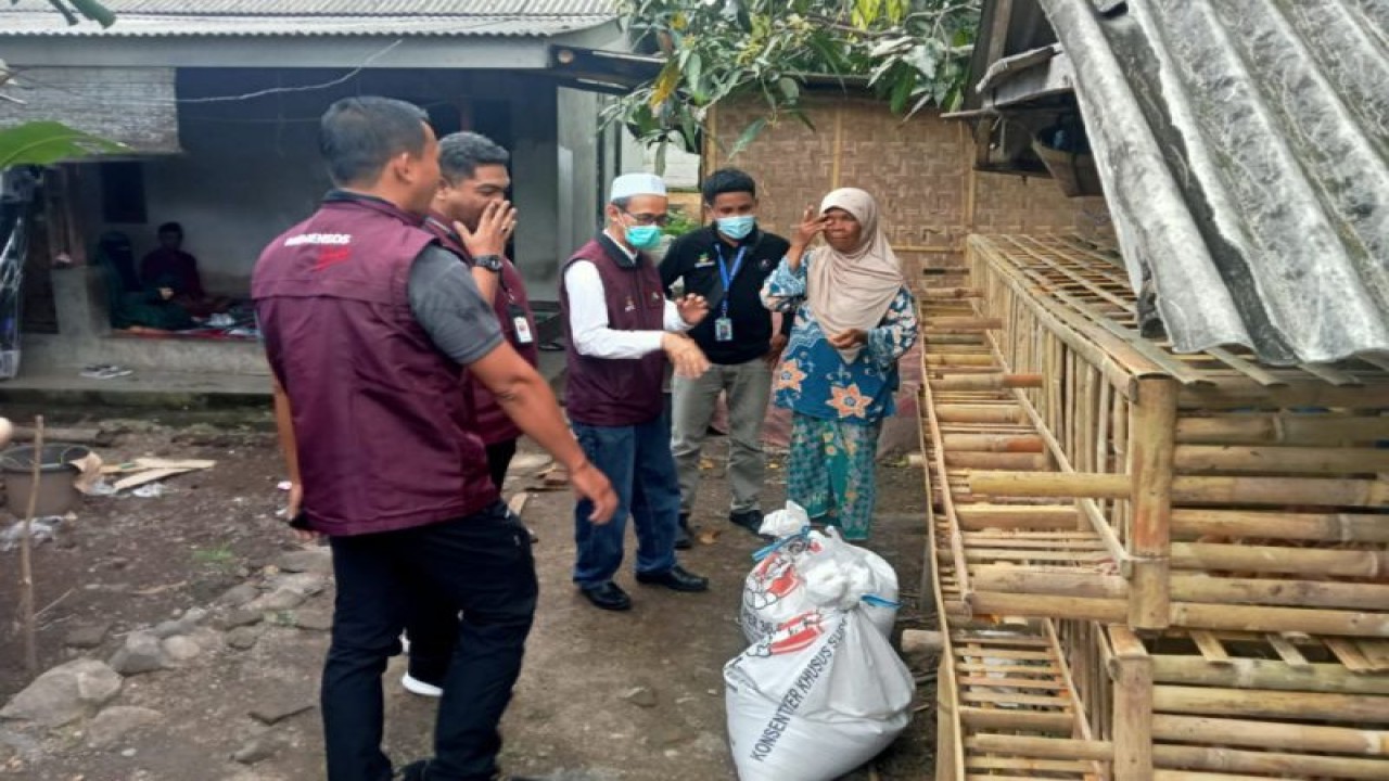 Petugas menyerahkan bantuan kepada ibu pemeran aksi mandi lumpur dalam konten TikTok di Desa Setanggor, Kecamatan Praya Barat, Kabupaten Lombok Tengah, Provinsi Nusa Tenggara Barat. (ANTARA/HO pekerja sosial Kabupaten Lombok Tengah)