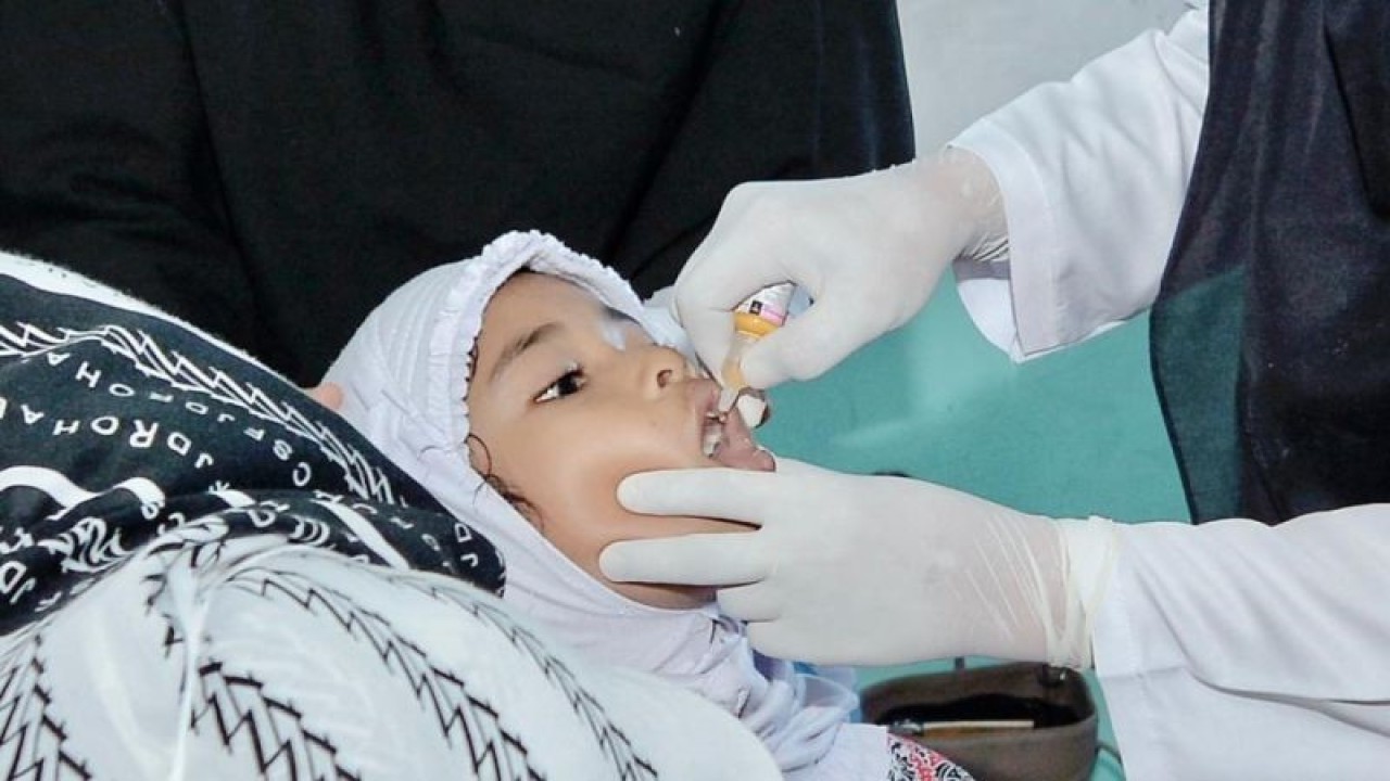 Petugas Dinas Kesehatan dan KB Kota Sabang meneteskan vaksin imunisasi polio kepada salah seorang siswi MIN 1 Sabang, Rabu (4/1/2022). (ANTARA/HO-Humas Pemkot Sabang)