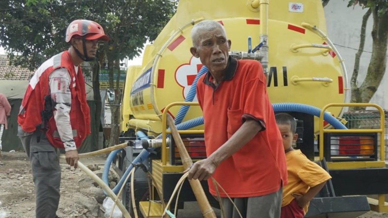 Relawan PMI menyalurkan bantuan air bersih kepada warga yang terdampak gempa di Kabupaten Cianjur, Provinsi Jawa Barat. (ANTARA/Ahmad Fikri)