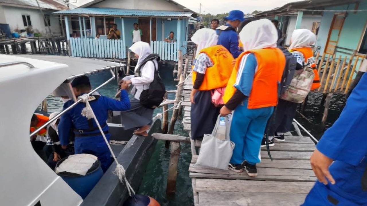 Personel Polda Kepri menjemput siswa sekolah di salah satu pelabuhan untuk diantarkan ke pulau. (ANTARA/HO-Humas Polda Kepri)