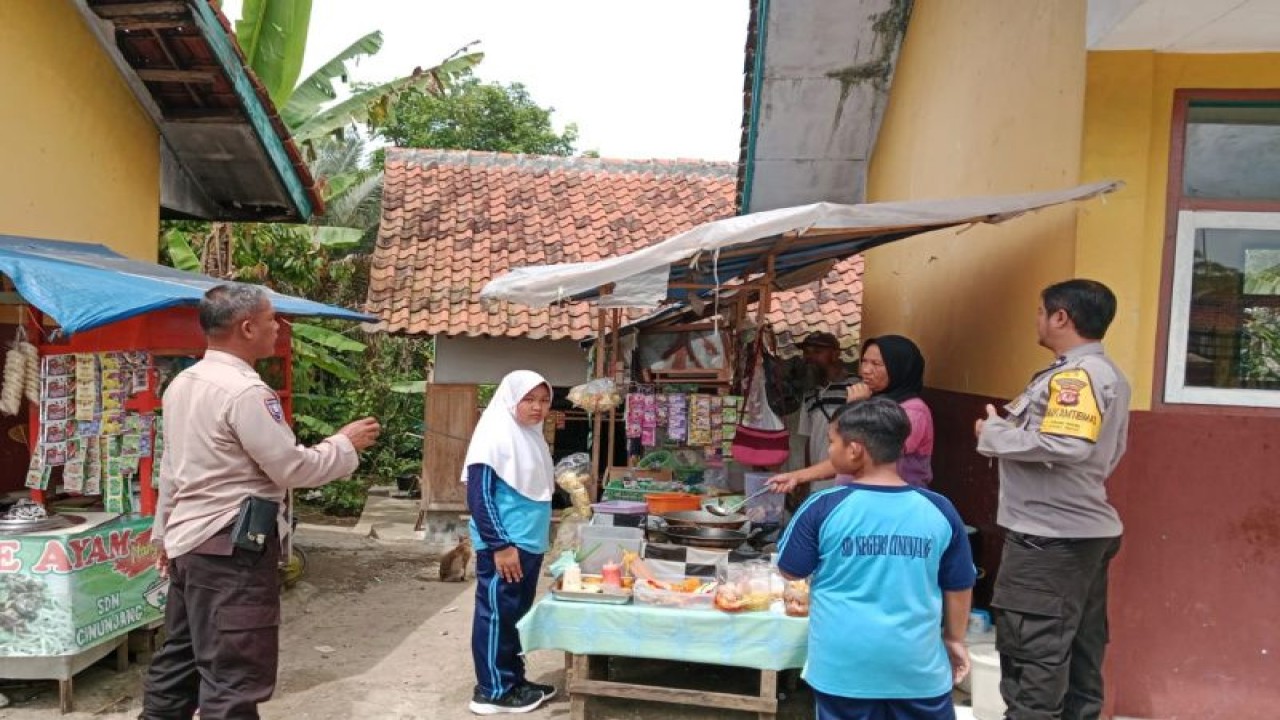 Sejumlah polisi mengecek jajanan makanan dan minuman di sekolahan, Kecamatan Gunung Tanjung, Kabupaten Tasikmalaya, Jawa Barat, Kamis (19/1/2023). (ANTARA/HO-Polres Tasikmalaya Kota)