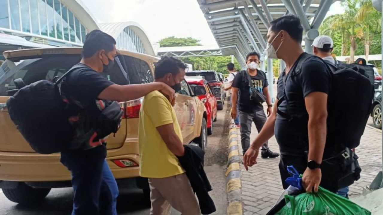 Polisi mengawal tersangka perekrut PMI usia anak berinisial IS (kedua kiri) yang tertangkap di Jakarta, setibanya di Bandara International Zainuddin Abdul Madjid, NTB, Jumat (9/12/2022). (ANTARA/HO-Polda NTB)