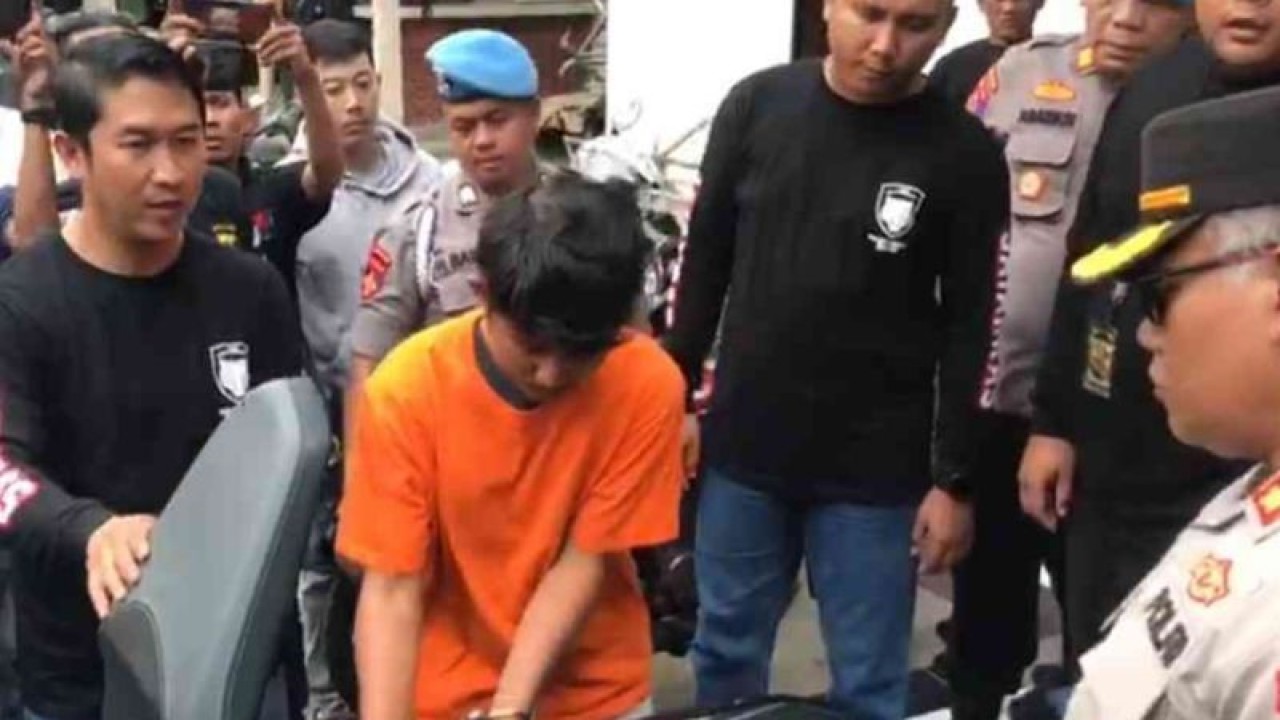 Petugas kepolisian meminta pelaku menunjukkan tempat menyembunyikan senjata tajam jenis celurit yang dipakai untuk membunuh anggota ormas di sebuah tempat hiburan malam saat rekonstruksi kasus di Mapolres Metro Bekasi, Senin. (ANTARA/Pradita Kurniawan Syah).