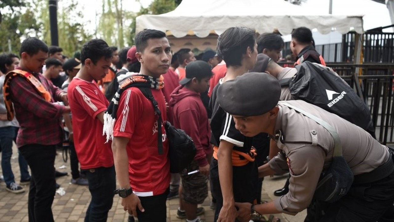 Polisi memeriksa barang bawaan penonton pertandingan Liga-1 Persija Jakarta melawan Persib Bandung di Stadion Utama Gelora Bung Karno (GBK) Senayan, Jakarta, Rabu (10/7/2019). (ANTARA FOTO/M Risyal Hidayat/wsj)