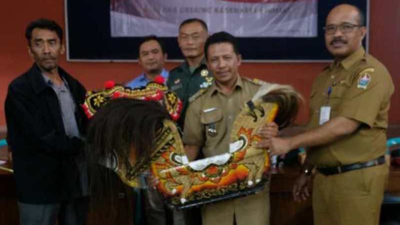Kepala Dinas Sosial Kabupaten Temanggung Prasodjo (kanan) menyerahkan bantuan seperangkat alat kesenian kuda lumping di Desa Bansari, Kecamatan Bansari. ANTARA/Anis Efizudin