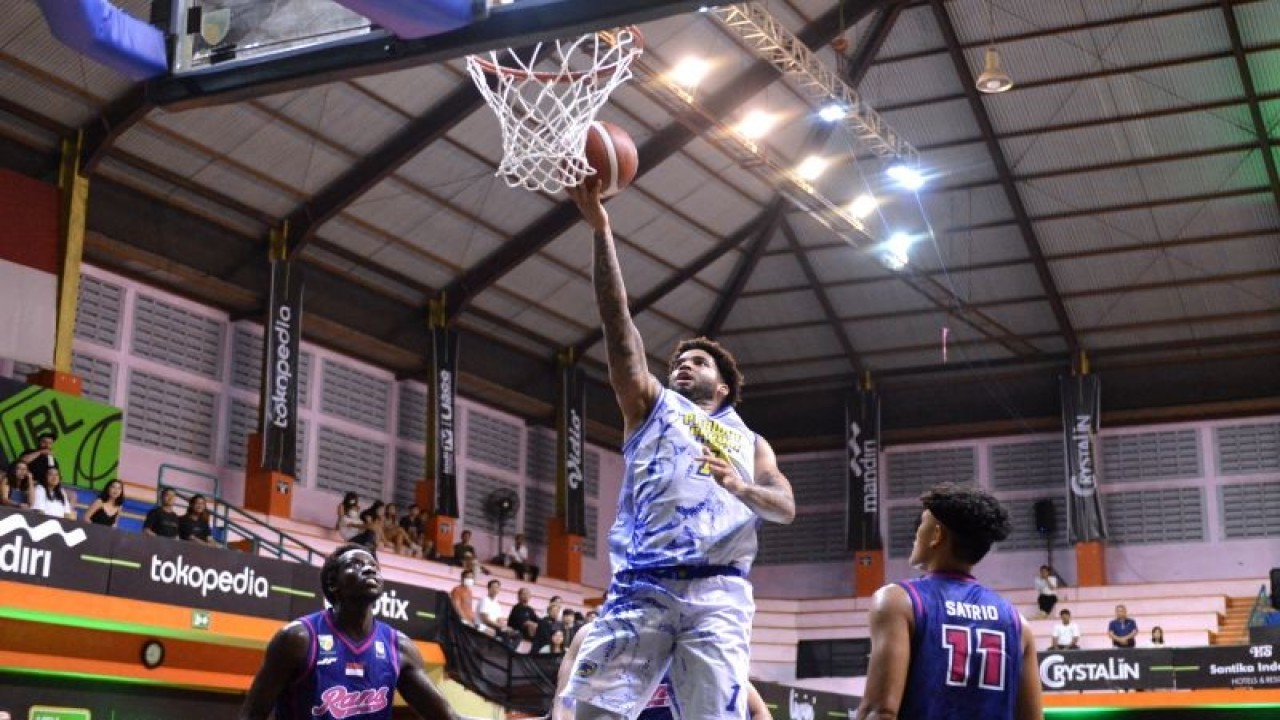 Pebasket Prawira Harum Bandung Brandone Francis (tengah) memasukkan bola saat pertandingan melawan RANS PIK Basketball dalam Indonesian Basketball League (IBL) 2023 di GOR Merpati, Denpasar, Bali, Kamis (19/1/2023). Prawira Harum Bandung menang atas RANS PIK Basketball dengan skor 78-61. ANTARA FOTO/Fikri Yusuf/YU