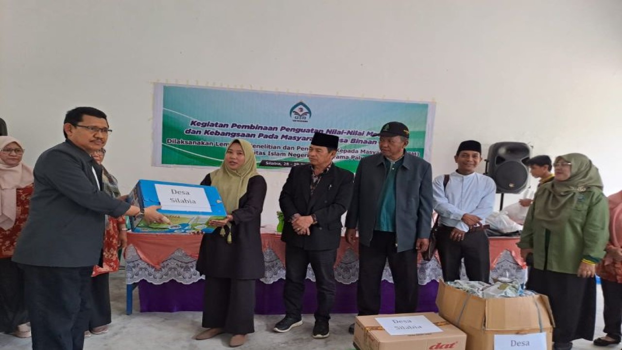 Rektor UIN Datokarama Prof Sagaf S Pettalongi menyerahkan bantuan kepada warga di Desa Silabia, Kabupaten Parigi Moutong. (ANTARA/HO-LP2M UIN Datokarama)