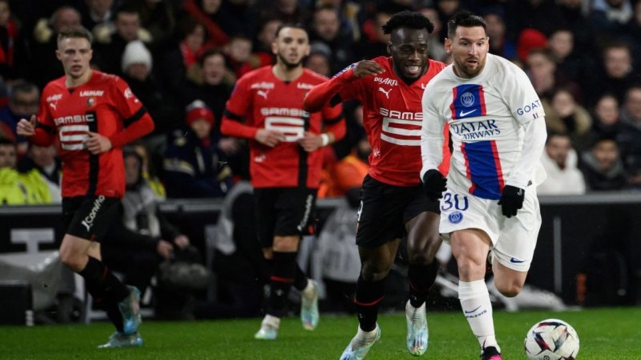 Pemain PSG Lionel Messi (kanan) ditempel penyerang Rennes Arnaud Kalimuendo saat menggiring bola dalam pertandingan Liga Prancis di Roazhon Park stadium, Rennes pada 16 Januari 2023. ANTARA/AFP/LOIC VENANCE