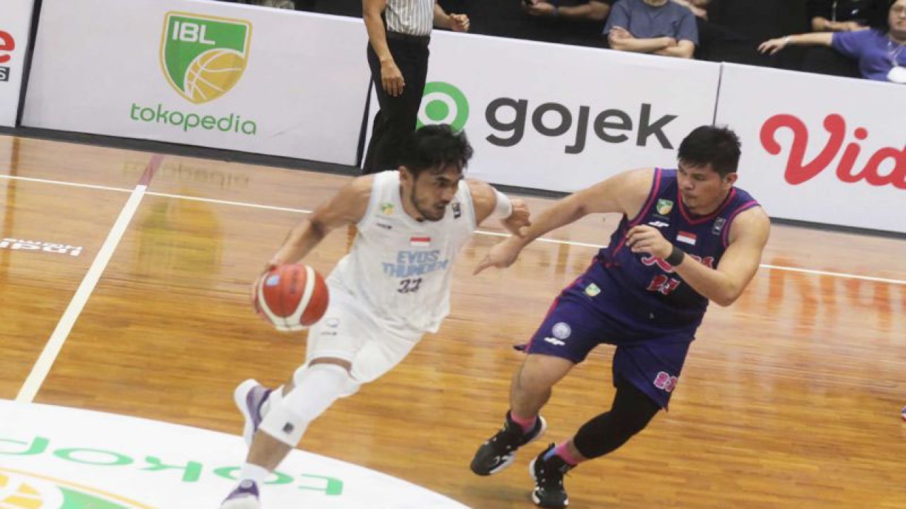 Pemain RANS PIK Basketball Club (kanan) mengawal pergerakan pemain Evos Thunder Bogor pada pertandingan seri kedua musim 2023 Liga Basket Indonesia (IBL), yang digelar di GOR Bimasakti, Kota Malang, Jawa Timur, Sabtu (28/1/2023). ANTARA FOTO/Ari Bowo Sucipto.
