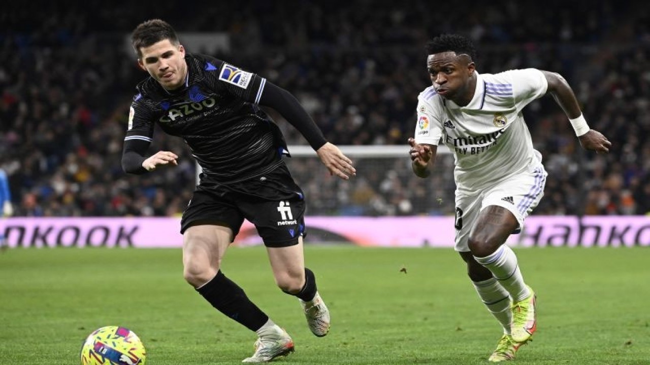 Penyerang Real Madrid Vinicius Junior (kanan) berduel dengan gelandang Real Sociedad Igor Zubeldia pada pertandingan Liga Spanyol yang dimainkan di Stadion Santiago Bernabeu, Madrid, Minggu (29/1/2023). (ANTARA/AFP/OSCAR DEL POZO)