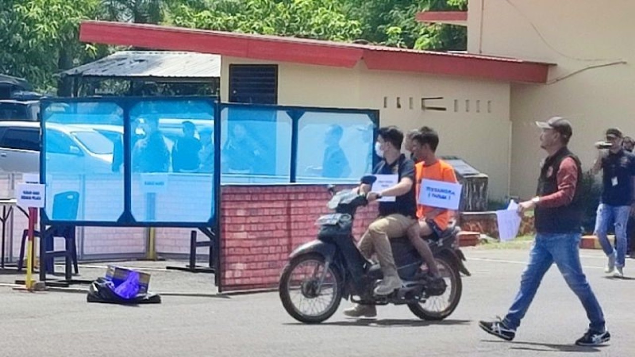 Wakasat Reskrim Polrestabes Makassar Kompol Jufri Natsir (kanan) saat memandu proses rekonstruksi tersangka MF (18) sedang dibonceng (dua kiri) atas kasus penculikan dan pembunuhan berencana nak korban MFS (11) di Mako Satuan Brimob Polda Sulsel, Makassar, Selasa (17/1/2022). ANTARA/Darwin Fatir.