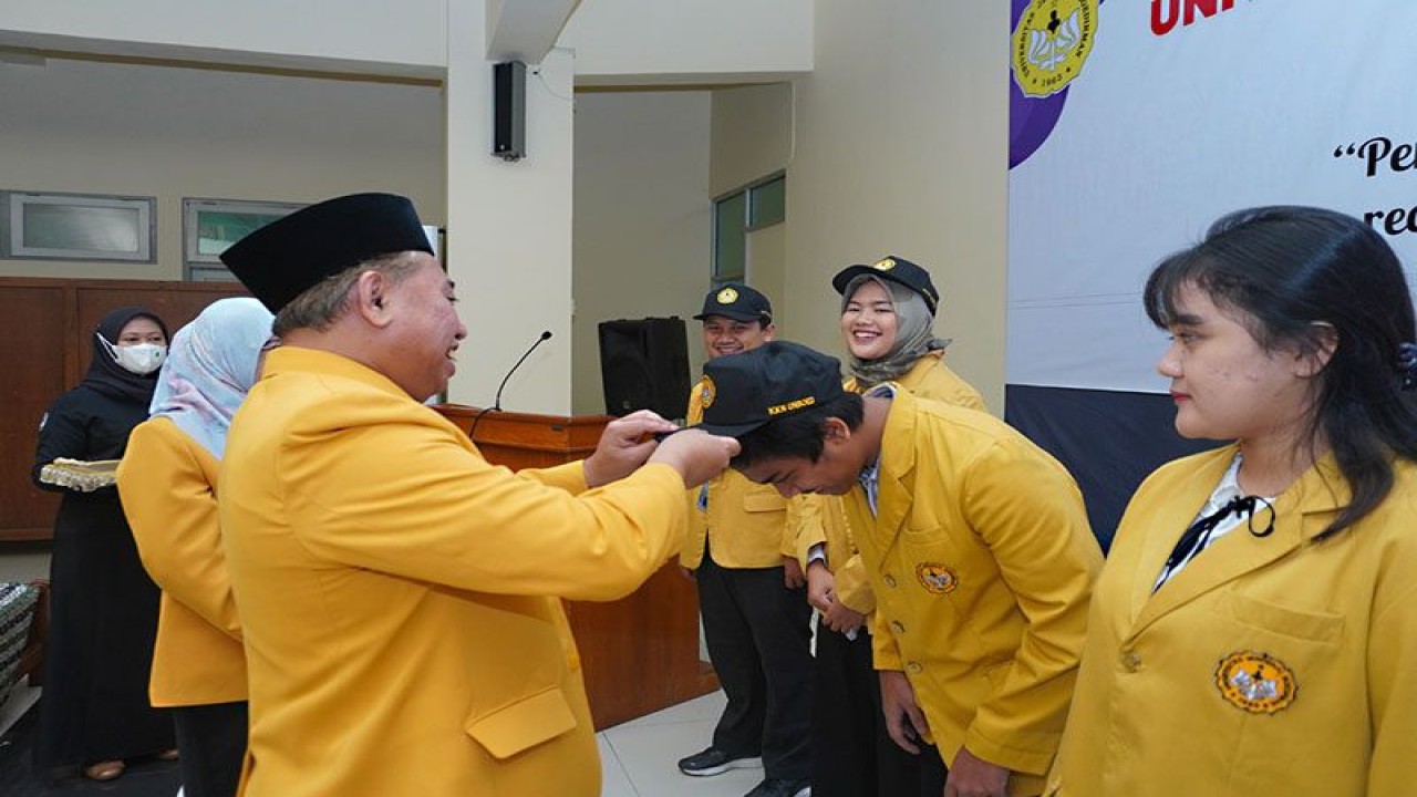 Rektor Universitas Jenderal Soedirman (Unsoed) Purwokerto Prof. Akhmad Sodiq memakaikan atribut kuliah kerja nyata (KKN) kepada perwakilan mahasiswa peserta KKN dalam acara Pelepasan KKN Tematik Periode Januari-Februari 2023 di Hall Lembaga Penelitian dan Pengabdian Kepada Masyarakat (LPPM) Unsoed, Purwokerto, Rabu (4/1/2023). ANTARA/HO-Unsoed