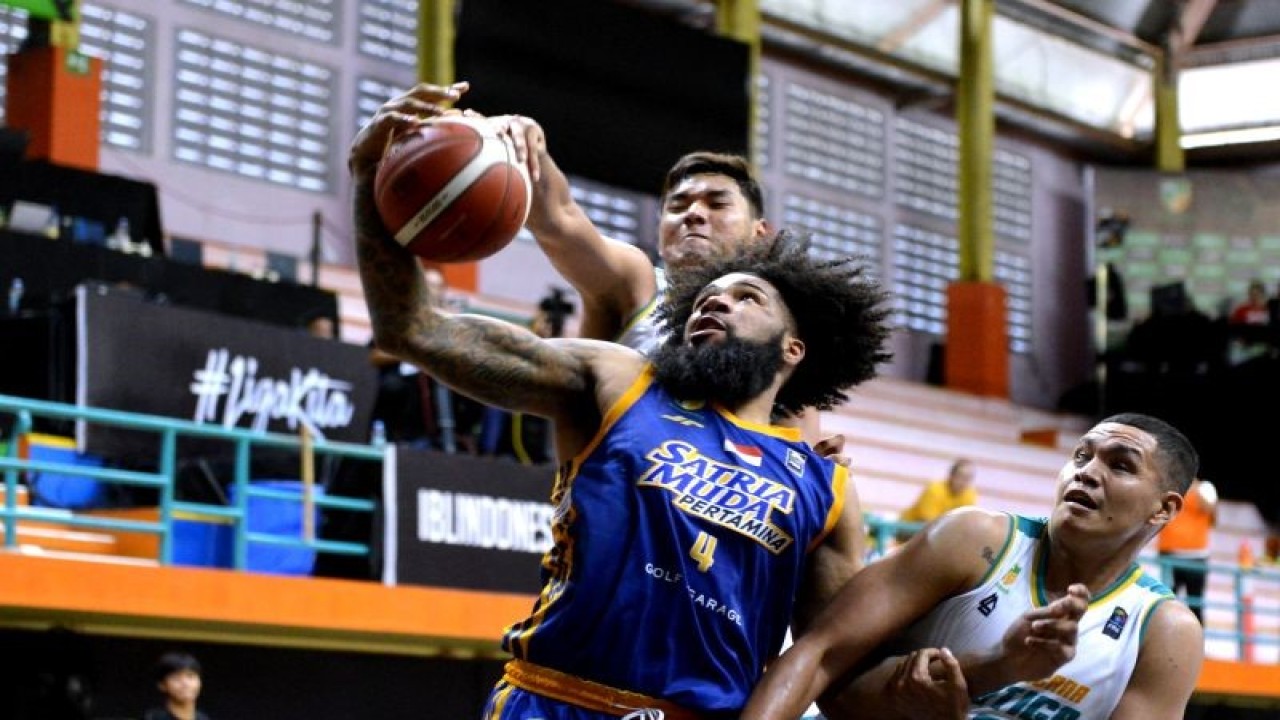 Pebasket Satria Muda Pertamina Jakarta Elijah Johad Foster (tengah) berebut bola dengan pebasket Satya Wacana Salatiga Naufal Narendra Ranggajaya (kiri) dan Henry Cornelis Lakay (kanan) saat pertandingan Indonesian Basketball League (IBL) 2023 di GOR Merpati, Denpasar, Bali, Sabtu (21/1/2023). ANTARA FOTO/Fikri Yusuf/YU (ANTARA FOTO/FIKRI YUSUF)