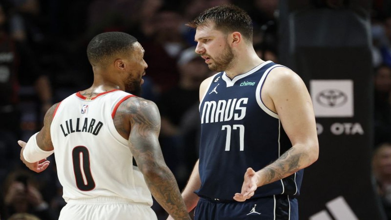 Pebasket Portland Trail Blazers Damian Lillard (kiri) berbicara dengan pebasket Dallas Mavericks Luka Doncic saat kuarter keempat pertandingan NBA kedua tim di Moda Center Portland, Oregon, Sabtu (14/1/2023) (Getty Images via AFP/STEPH CHAMBERS)