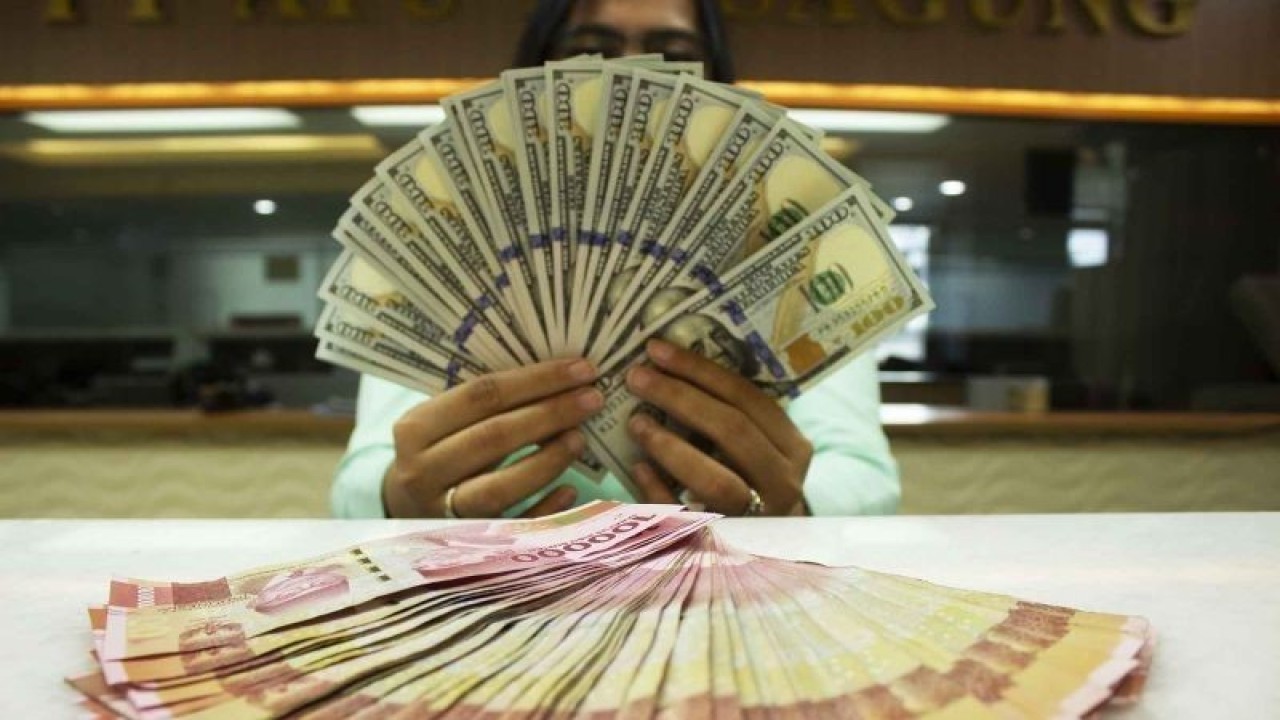 Teller memegang mata uang Dolar AS dan Rupiah di sebuah tempat penukaran uang, Jakarta, Rabu (6/7/2022). Kurs Rupiah ditutup Rp14.999 per Dolar AS pada perdagangan Rabu (6/7) hari ini, melemah 0,03 persen ketimbang posisi penutupan perdagangan kemarin (5/7) pada Rp 14.994 per dolar AS. (ANTARA FOTO/Subur Atmamihardja/wsj/foc.)