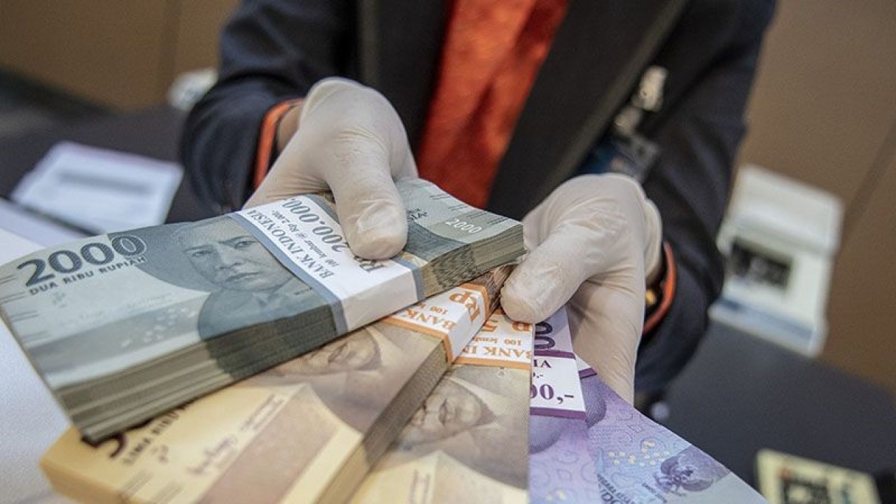 Ilustrasi - Petugas bank menunjukkan uang pecahan rupiah di BNI KC Mega Kuningan, Jakarta, Selasa (22/11/2022). ANTARA FOTO/Muhammad Adimaja/aww/pri.