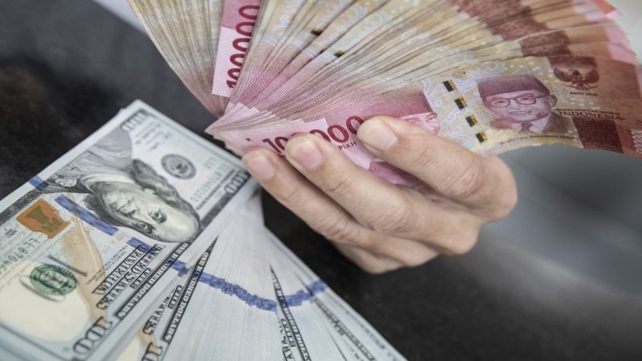 Petugas menunjukan uang pecahan rupiah dan dolar AS di gerai penukaran mata uang asing VIP (Valuta Inti Prima) Money Changer, Jakarta, Selasa (3/1/2023). ANTARA FOTO/Muhammad Adimaja/foc. (ANTARA FOTO/MUHAMMAD ADIMAJA)