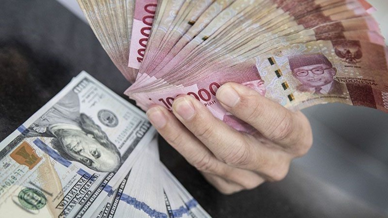 Ilustrasi - Petugas menunjukan uang pecahan rupiah dan dolar AS di gerai penukaran mata uang asing VIP (Valuta Inti Prima) Money Changer, Jakarta, Selasa (3/1/2023). ANTARA FOTO/Muhammad Adimaja/foc/pri. (ANTARA FOTO/MUHAMMAD ADIMAJA)