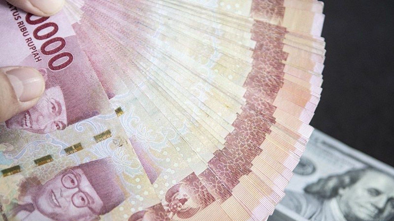 Petugas menunjukan uang pecahan rupiah dan dolar AS di gerai penukaran mata uang asing VIP (Valuta Inti Prima) Money Changer, Jakarta, Selasa (3/1/2023). ANTARA FOTO/Muhammad Adimaja/foc/pri.