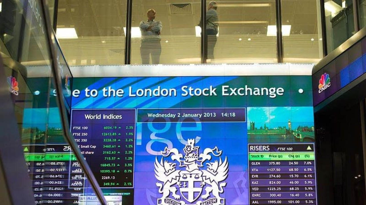 Pekerja terlihat berbincang di atas papan elektronik pergerakan saham di London Stock Exchange, Inggris. REUTERS/Paul Hackett/aa. (REUTERS/Paul Hackett)