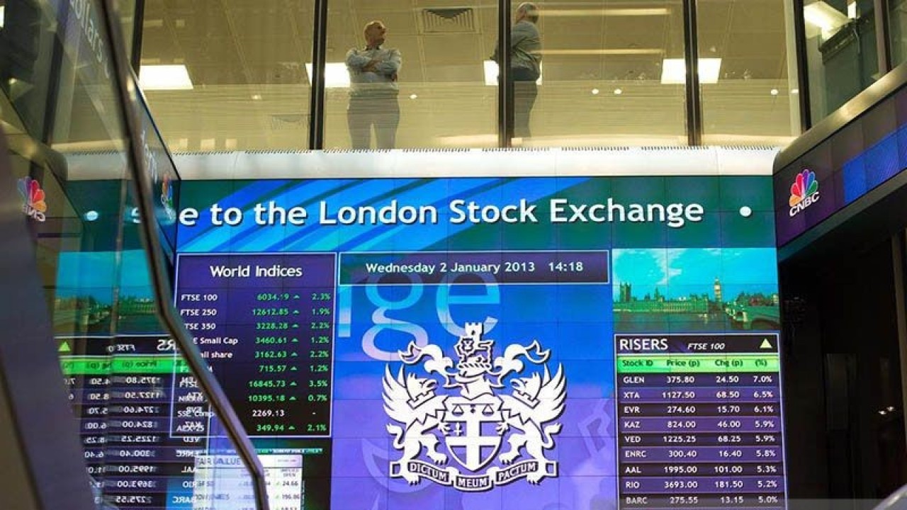 Pekerja terlihat berbincang di atas papan elektronik pergerakan saham di London Stock Exchange, Inggris. REUTERS/Paul Hackett/aa. (REUTERS/Paul Hackett)