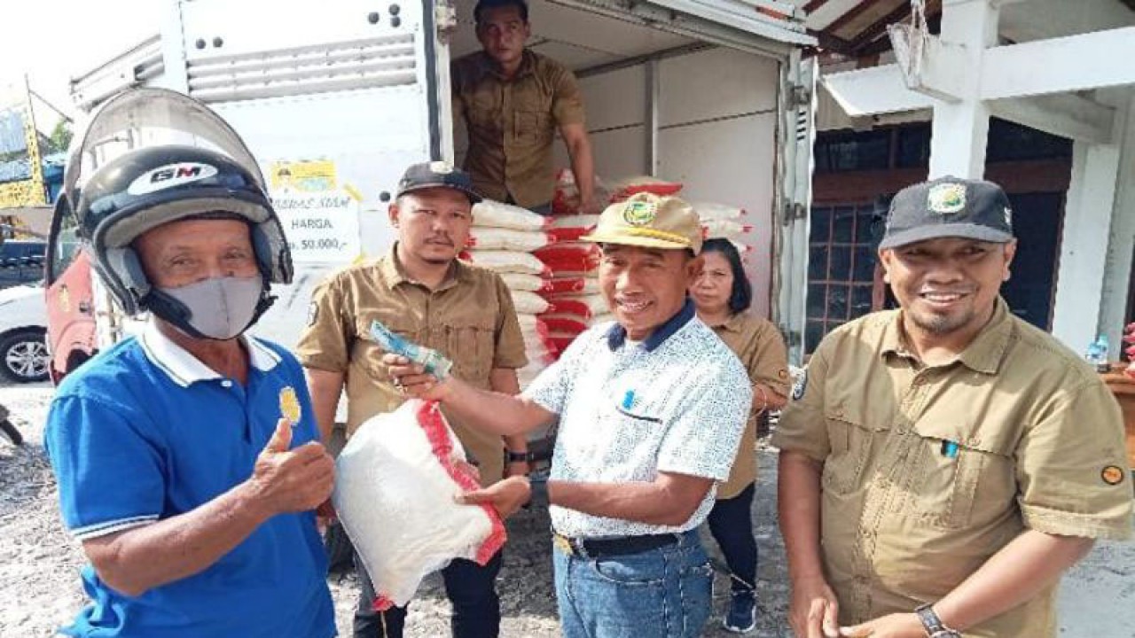 Kepala DPKUKMP Palangka Raya Samsul Rizal menyerahkan secara simbolis kepada warga yang membeli beras murah yang disediakan instansi terkait di Jalan Ahmad Yani, Jumat (13/1/2023). ANTARA/Adi Wibowo