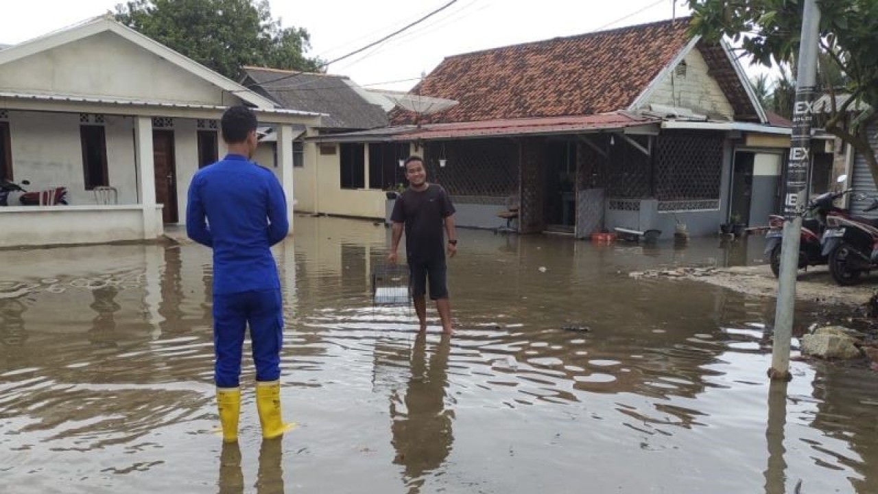 Personel Satpolair Polres Bangka Barat memantau ketinggian air laut pasang yang masuk permukiman warga di Kelurahan Tanjung, Mentok. ANTARA/ Donatus Dasapurna
