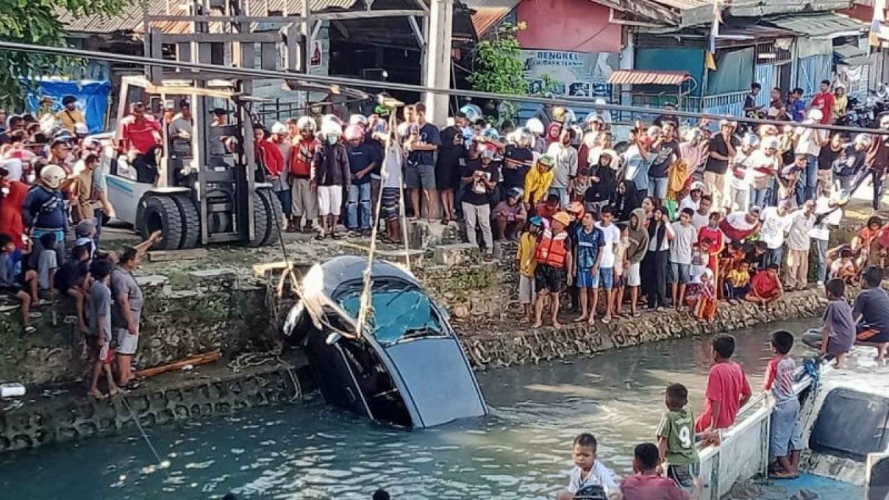 Satu unit mobil mengalami musibah terjun ke laut di Kota Baubau, Sultra, Sabtu (14/1/2023). Nampak proses evakuasi dilakukan. ANTARA/Yusran