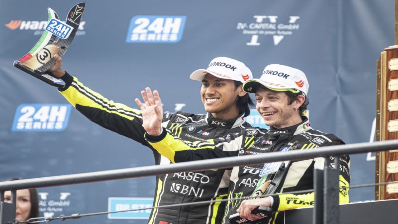 Pebalap Indonesia Sean Gelael (kiri) bersama Valentino Rossi melakukan selebrasi setelah naik podium ketiga dalam balapan 24H Dubai di Dubai Autodrome, Uni Emirat Arab, Minggu (15/1/2023). (ANTARA/HO-WRT)