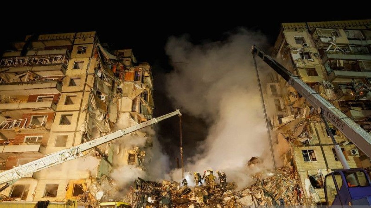 Petugas melakukan evakuasi korban reruntuhan apartemen yang hancur karena serangan rudal Rusia di Dnipro, Ukraina, Sabtu (14/1/2022) malam. Reuters melaporkan Rusia melepaskan gelombang serangan besar yang memukul infrastruktur energi di Ukraina termasuk sebuah gedung apartemen sembilan lantai di kota Dnipro yang menyebabkan 12 orang tewas. ANTARA FOTO/REUTERS/Clodagh Kilcoyne/pras.