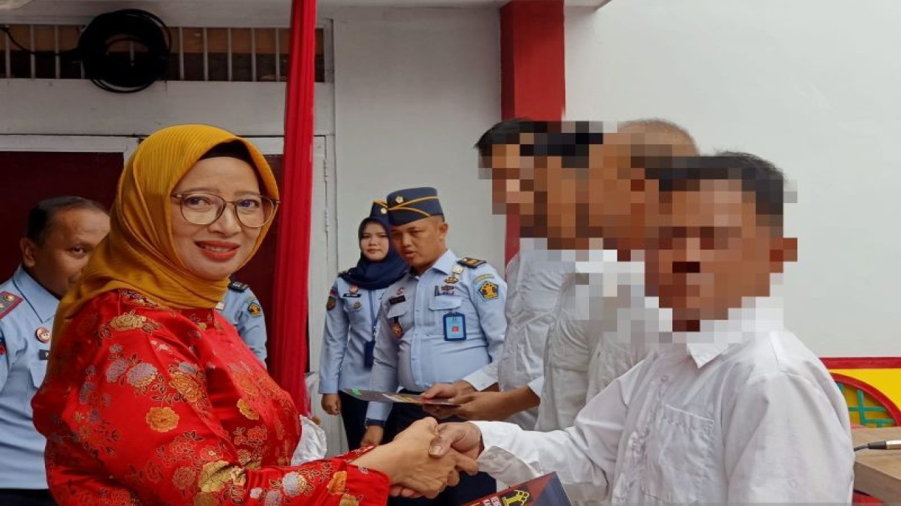 Kepala Divisi Pemasyarakatan Kanwil Kemenkum dan HAM Kalbar Ika Yusanti menyerahkan remisi Tahun Baru Imlek 2574 kepada sembilan narapidana yang beragama Konghucu.  (ANTARA/rudi)