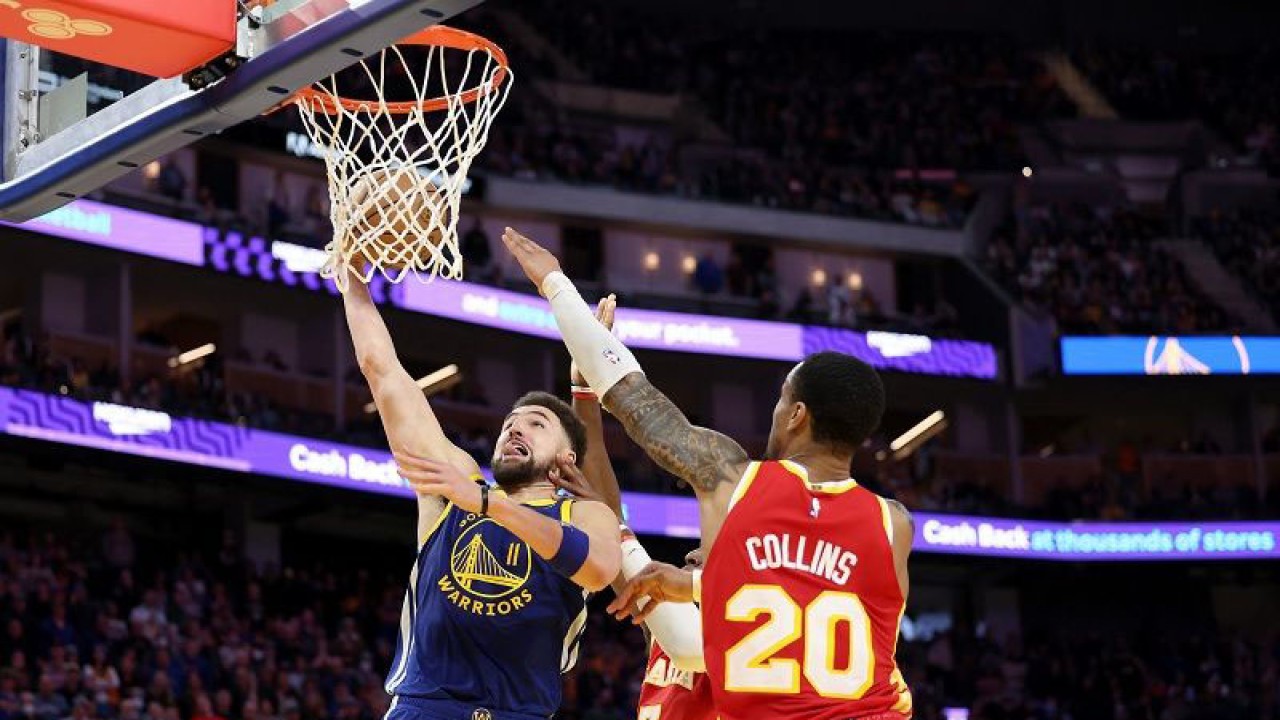 Bintang Golden State Warriors Klay Thompson (kiri) berusaha mencetak angka di hadapan pemain Atlanta Hawks John Collins dalam gim lanjutan NBA di Chase Center, California, Amerika Serikat, Senin (2/1/2023) waktu setempat. (ANTARA/AFP/GETTY IMAGES/Ezra Shaw)
