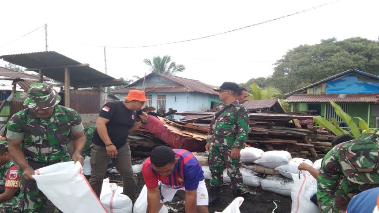 Petugas BPBD dan TNI membangun tanggul sementara untuk mengatasi banjir rob di bagian wilayah Desa Wosia, Kabupaten Halmahera Utara, Provinsi Maluku Utara. (HO BPBD)