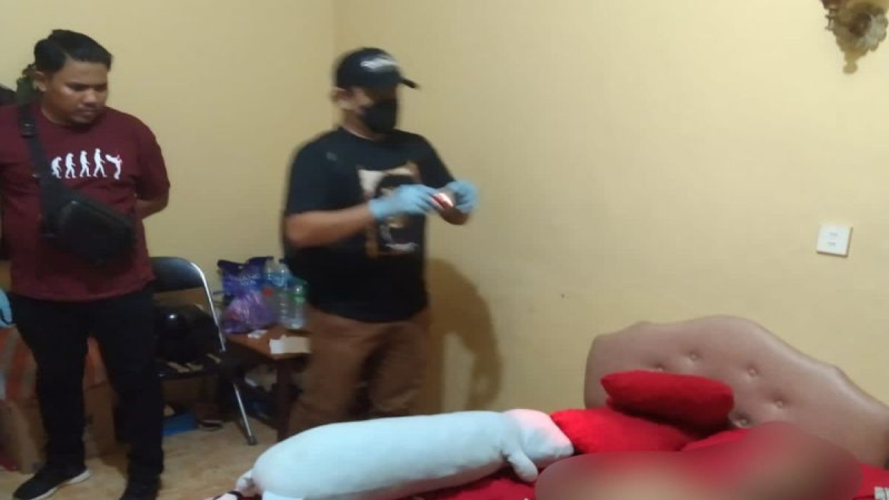 Personel polisi mengidentifikasi jasad pria yang ditemukan meninggal di kamar hotel Tanjungpinang, Rabu malam, (11/1). (ANTARA/HO-Polsek Tanjungpinang Kota)