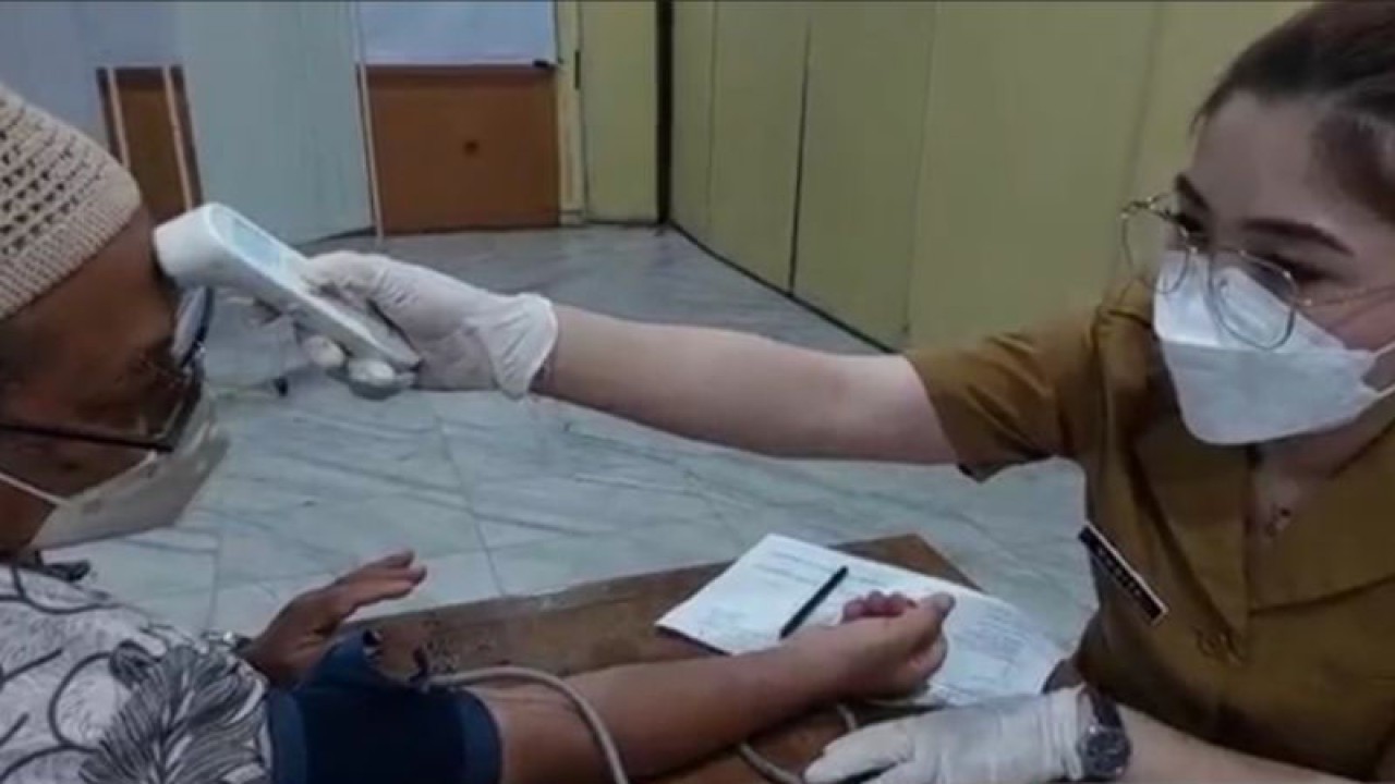 Petugas kesehatan tengah memeriksa suhu dan tensi kepada salah satu warga sebelum di vaksin COVID-19 booster kedua di Kantor Wali Kota Jakarta Timur, Cakung, Selasa (24/1/2023). ANTARA/Syaiful Hakim