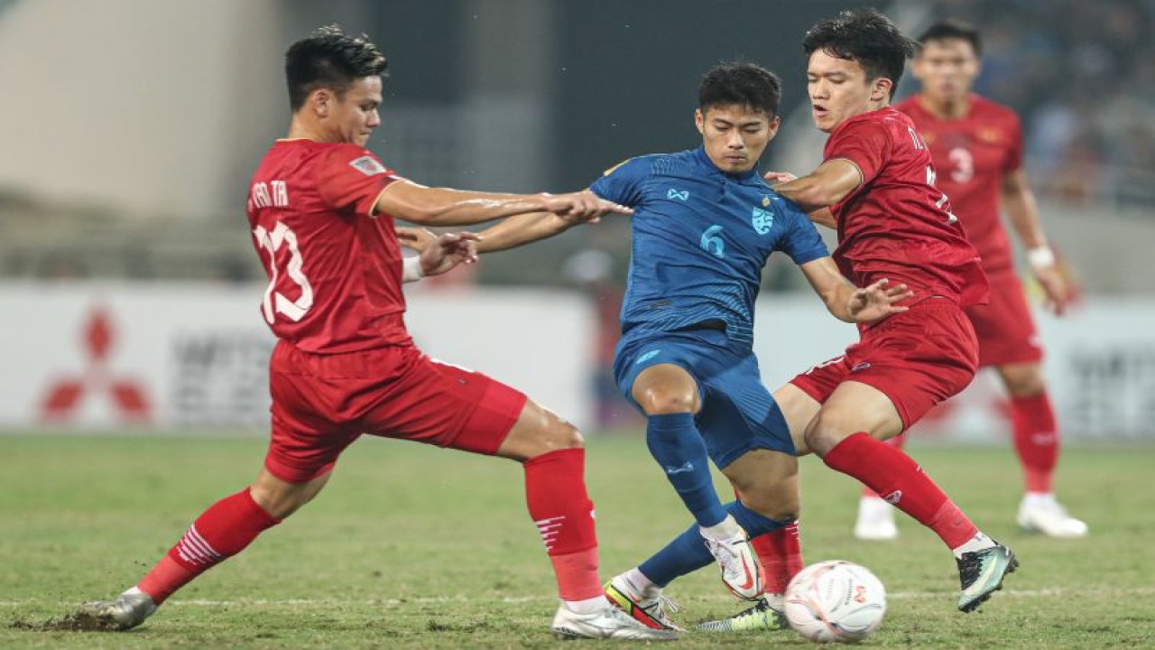 Gelandang tim nasional Thailand Sarach Yooyen (tengah) berebut bola dengan pemain Vietnam pada laga leg pertama final Piala AFF 2022 di Stadion Nasional My Dinh, Hanoi, Vietnam, yang berakhir imbang 2-2, Jumat (13/1/2023). (ANTARA/HO-AFF)