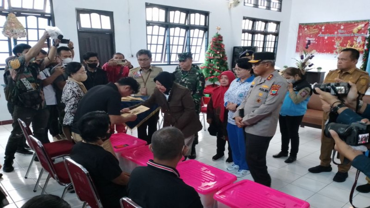 Menteri Sosial Tri Rismaharini saat menyerahkan bantuan kepada keluarga korban banjir dan tanah longsor di Manado. ANTARA/Jorie Darondo (1)