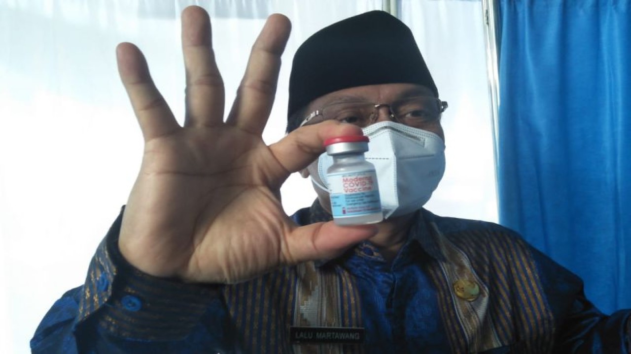 Asisten I Bidang Administrasi Pemerintahan dan Kesejahteraan Rakyat Setda Kota Mataram Lalu Martawang, menunjukkan botol vaksin setelah melakukan vaksinasi booster tahap pertama. (Foto: FOTO ANTARA/Nirkomala)