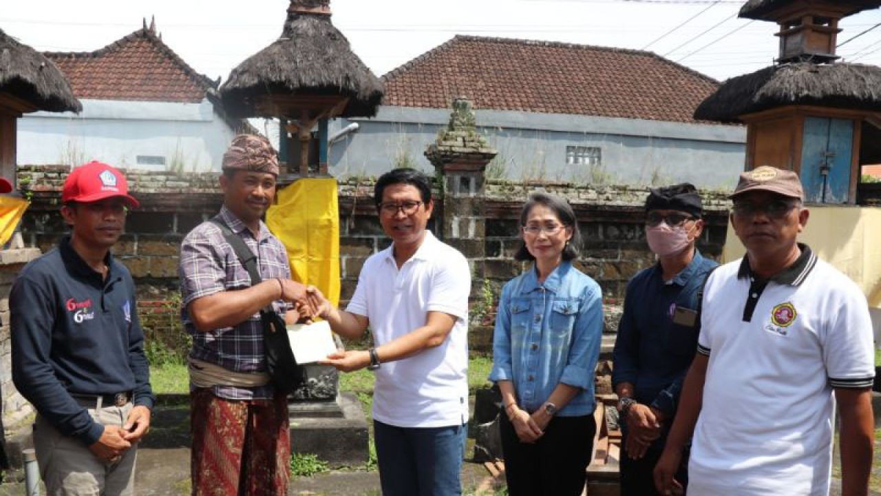 Sekda Badung I Wayan Adi Arnawa (tengah) menyerahkan bantuan stimulan kepada masyarakat terdampak bencana. ANTARA/HO-Pemkab Badung