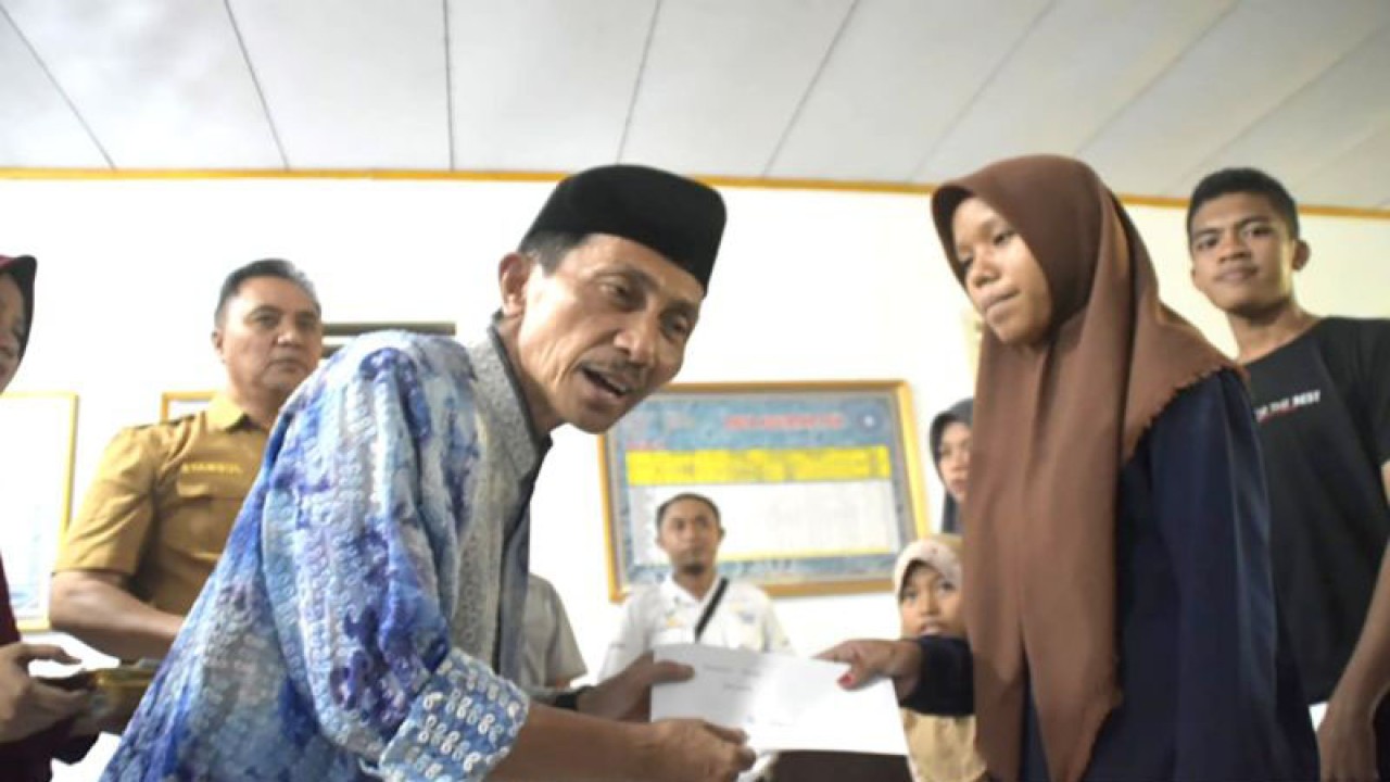 Bupati Gorontalo Nelson Pomalingo (kiri) menyerahkan bantuan Program Yatim Piatu (Yapi) kepada perwakilan anak yatim piatu di Kabupaten Gorontalo, Gorontalo. ANTARA/HO-Diskominfo Kabupaten Gorontalo