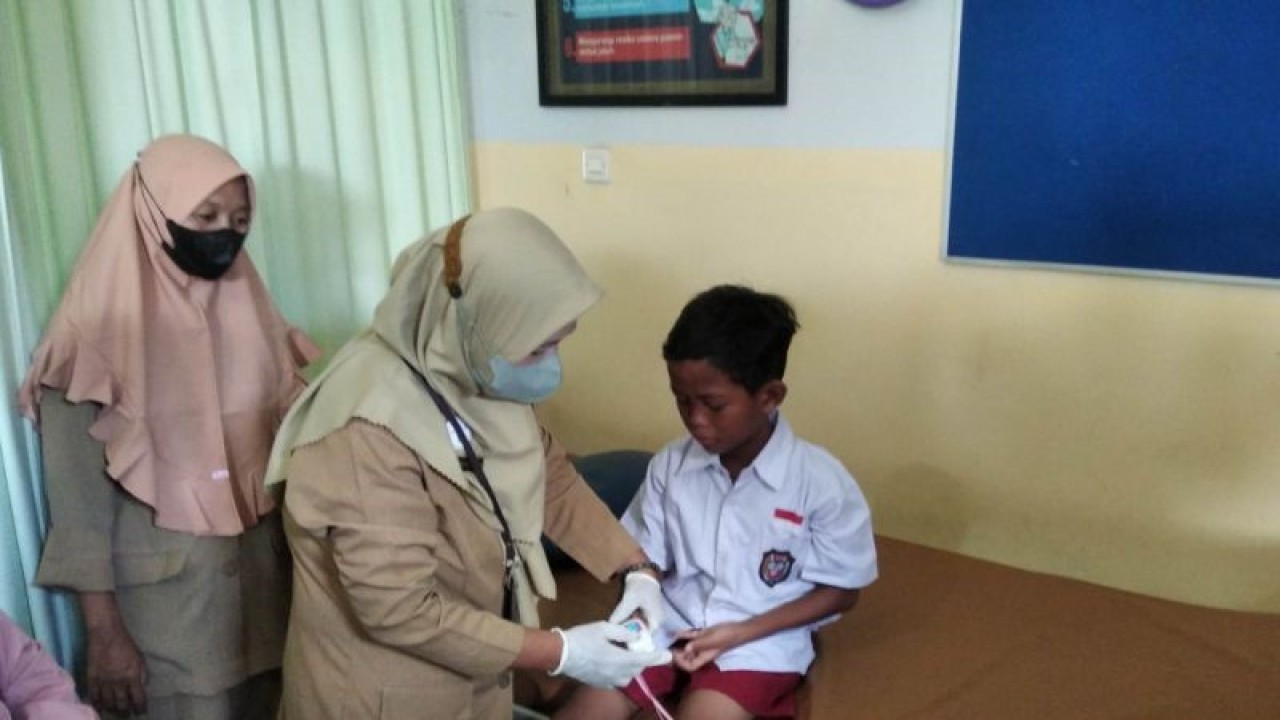 Seorang anak SD 2 Mejobo yang diduga keracunan menjalani pemeriksaan petugs Puskesmas Jepang, Kabupaten Kudus, Jawa Tengah, Senin (13/22023). (ANTARA/Akhmad Nazaruddin Lathif)
