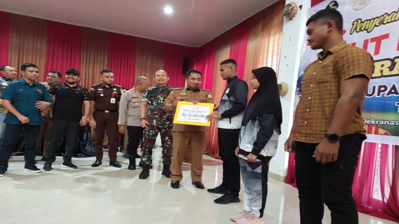 Pj Bupati Aceh Besar, Muhamamd Iswanto, menyerahkan bonus secara simbolis kepada atlet dan pelatih yang berhasil menyabet medali di  Pekan Olahraga Aceh (PORA) XIV di Pidie tahun 2022 yang lalu di Gedung Dekranasda Aceh Besar, Gampong Gani, Kecamatan Ingin Jaya, Senin (20/2/2023). (ANTARA/HO)