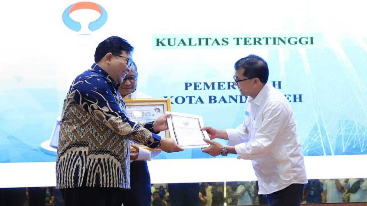 Pj Wali Kota Banda Aceh Bakri Siddiq (kanan) saat menerima penghargaan pelayanan publik dari pimpinan Ombudsman RI Dadan Suparjo Suharmawijaya (kiri) di Anjong Mon Mata, Banda Aceh, Rabu (22/2/2023). (FOTO ANTARA/HO-Humas Pemkot Banda Aceh)