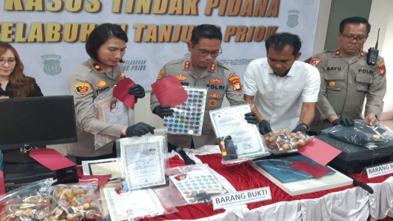Kepala Kepolisian Resor (Kapolres) Pelabuhan Tanjung Priok AKBP Ferikson Tampubolon (tengah) memegang barang bukti pemalsuan dokumen di wilayah Jakarta Utara yang berhasil disita di Markas Polres Pelabuhan Tanjung Priok, Jakarta Utara, Jumat (3/2/2023). ANTARA/HO-Polres Pelabuhan Tanjung Priok