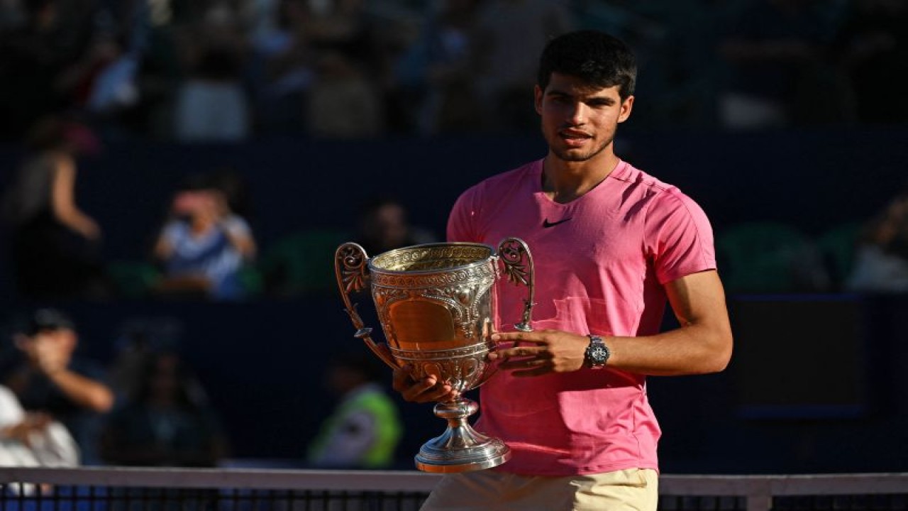 Petenis Spanyol Carlos Alcaraz menggenggam trofi setelah menjuarai turnamen Argentina Open dengan mengalahkan Cameron Norrie asal Inggris pada final di Buenos Aires, Argentina, Minggu (19/2/2023) (AFP/LUIS ROBAYO)