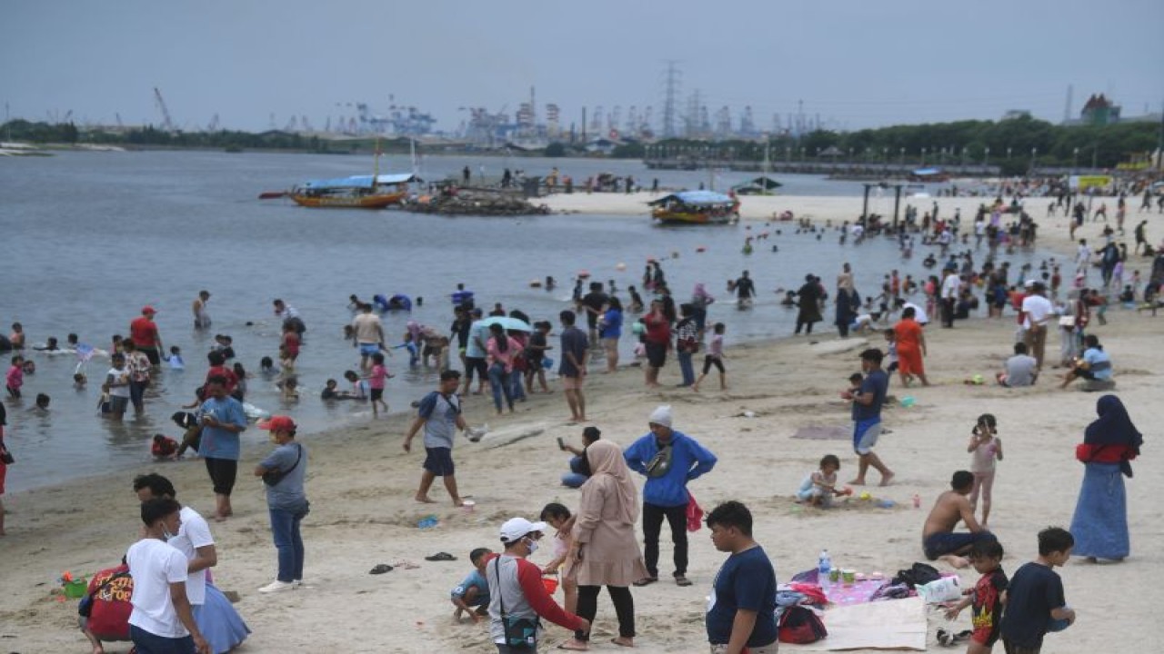 Pengunjung bersantai di tepi Pantai Ancol, Taman Impian Jaya Ancol, Jakarta, Selasa (3/5/2022). ANTARA FOTO/Akbar Nugroho Gumay/nym.