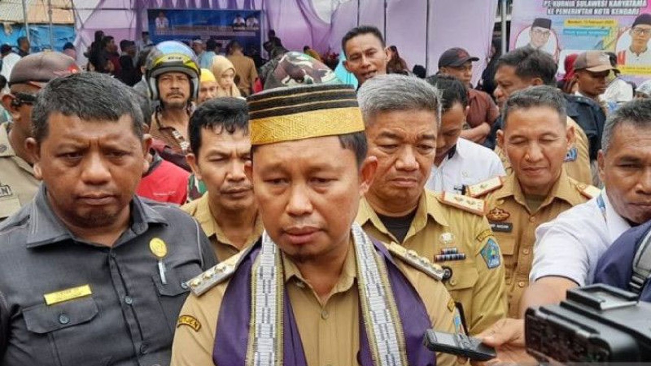 Pj.Walikota Kendari, Asmawa Tosepu (tengah) di dampingi Ketua DPRD Kendari Subhan (kiri) saat memberi keterangan terkait IPM Kendari 2022 yang naik peringkat empat tertinggi nasional. (ANTARA/Suparman)